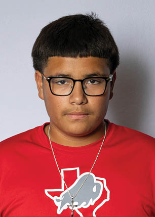 A young man wearing a white and black jersey with the number 14 on it. Description generated by AI