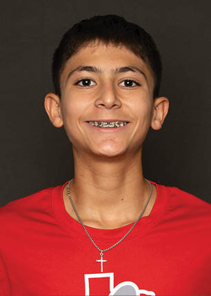 A young man wearing a white and black jersey with the number 14 on it. Description generated by AI