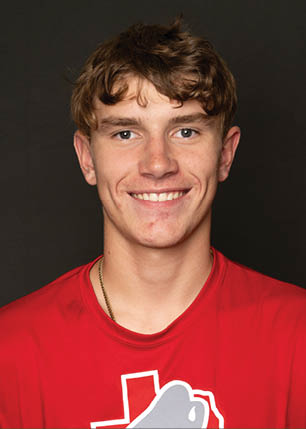A young man wearing a white and black jersey with the number 14 on it. Description generated by AI
