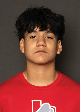 A young man wearing a white and black jersey with the number 14 on it. Description generated by AI