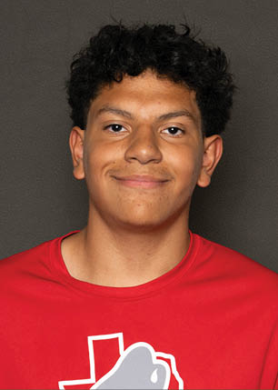 A young man wearing a white and black jersey with the number 14 on it. Description generated by AI