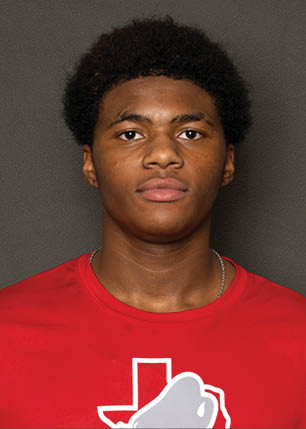 A young man wearing a white and black jersey with the number 14 on it. Description generated by AI