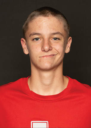A young man wearing a white and black jersey with the number 14 on it. Description generated by AI