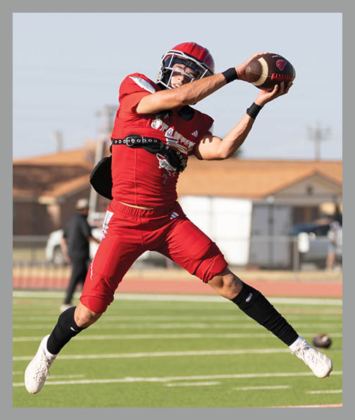 A football player in a white uniform is running with a football in his hand. AI generated content