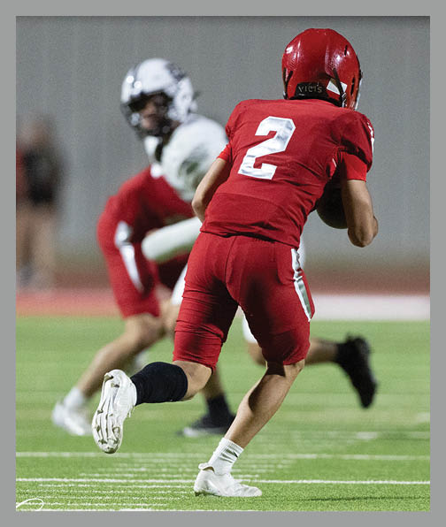A football player in a white uniform is running with a football in his hand. AI generated content