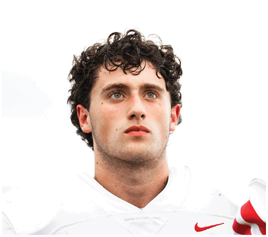 A person with curly hair wearing a white sports jersey with a red Nike logo looks thoughtfully into the distance against a bright background. Description generated by AI