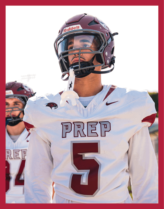 Three people wearing white sports uniforms with maroon numbers are standing outdoors. Description generated by AI
