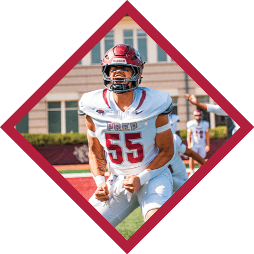 A person in a football uniform with the number 55 is celebrating energetically on a field while another person in a uniform with the number 98 raises their arms in the background near a scoreboard. Description generated by AI