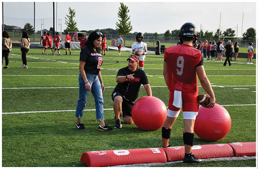 A football player catching a ball. Description generated by AI