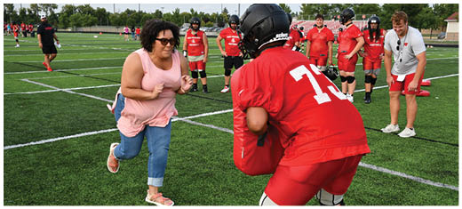 A football player catching a ball. Description generated by AI