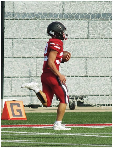 A football player running on the field. Description generated by AI