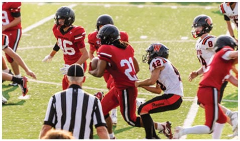A football player running on the field. Description generated by AI