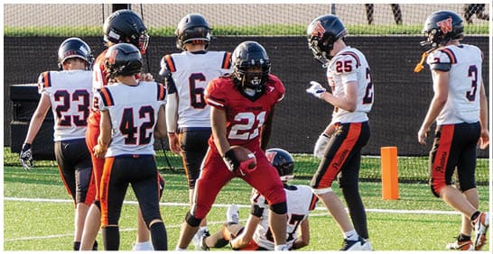 A football player running on the field. Description generated by AI