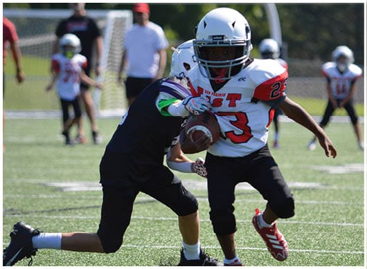 A football player catching a ball. Description generated by AI