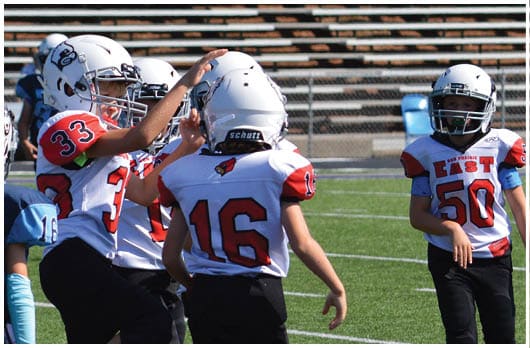 A football player catching a ball. Description generated by AI