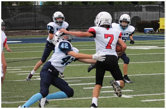 A football player catching a ball. Description generated by AI