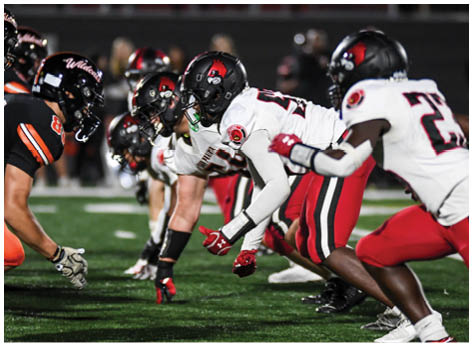 A football player wearing a blue and red jersey. Description generated by AI