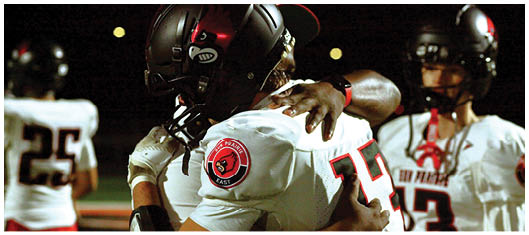 A football player catching a ball. Description generated by AI