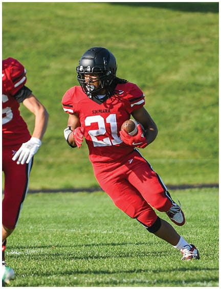 A football player running on the field. Description generated by AI