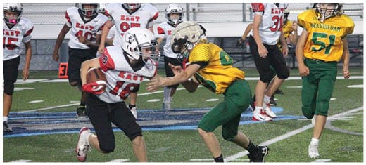 A football player catching a ball. Description generated by AI
