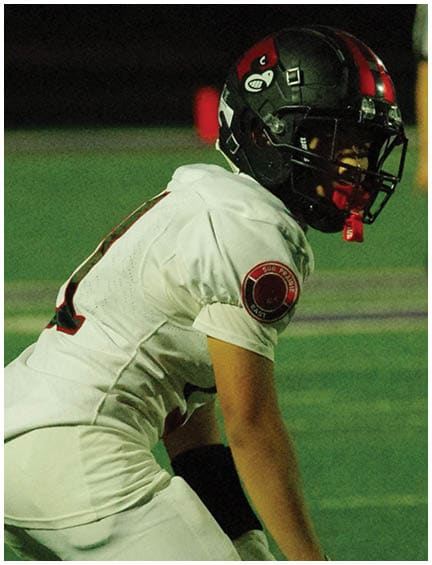A football player running on the field. Description generated by AI