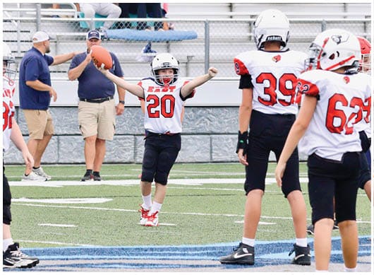 A football player catching a ball. Description generated by AI