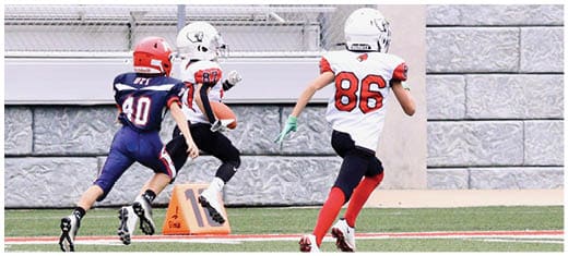 A football player catching a ball. Description generated by AI