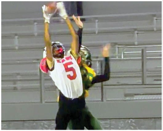A football player catching a ball. Description generated by AI