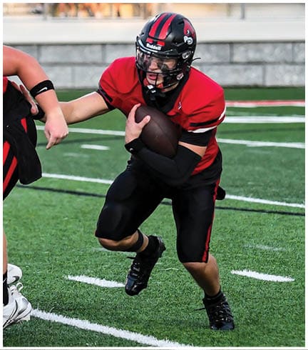 A football player running on the field. Description generated by AI