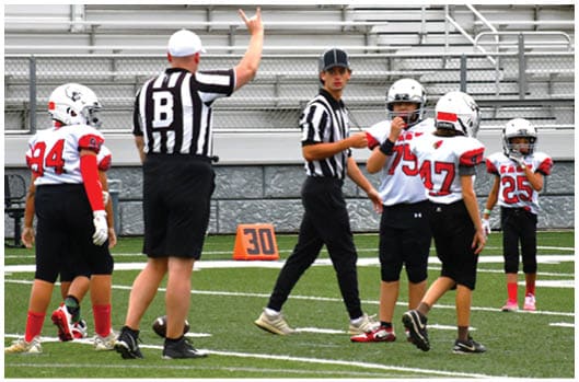 A football player catching a ball. Description generated by AI