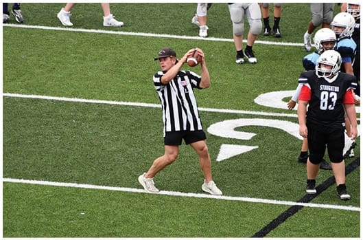 A football player catching a ball. Description generated by AI