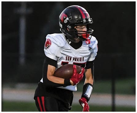 A football player running on the field. Description generated by AI