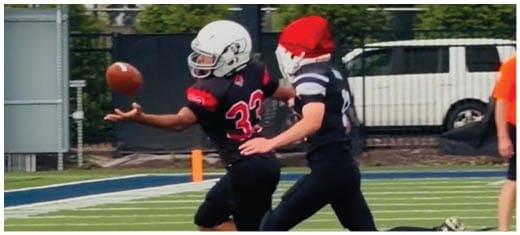 A football player catching a ball. Description generated by AI