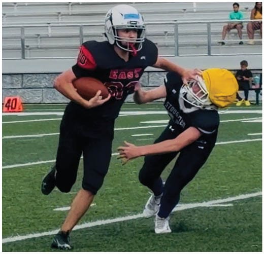 A football player catching a ball. Description generated by AI