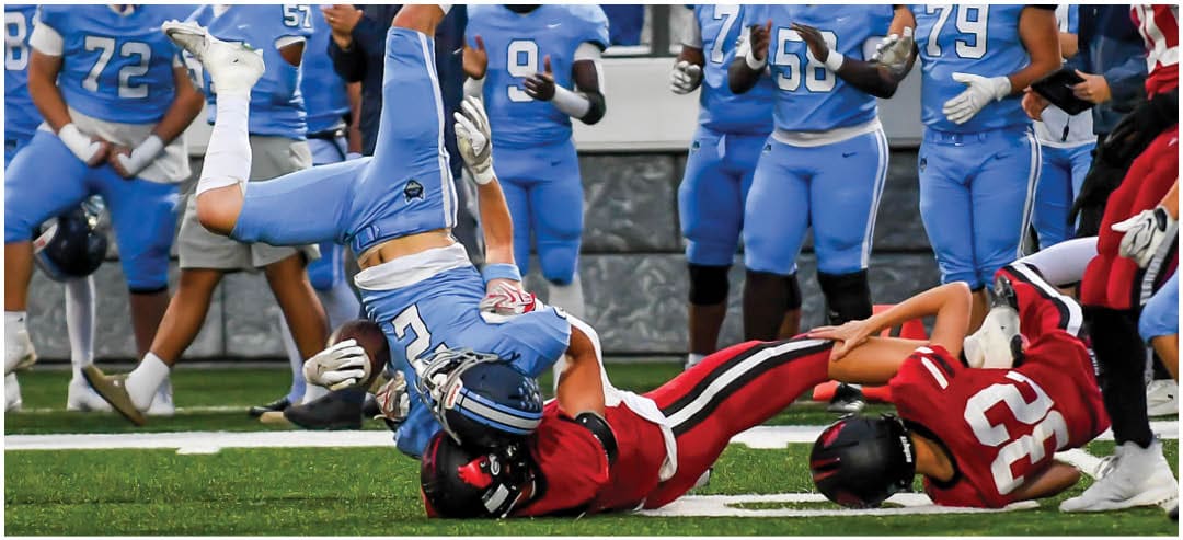 A football player catching a ball. Description generated by AI