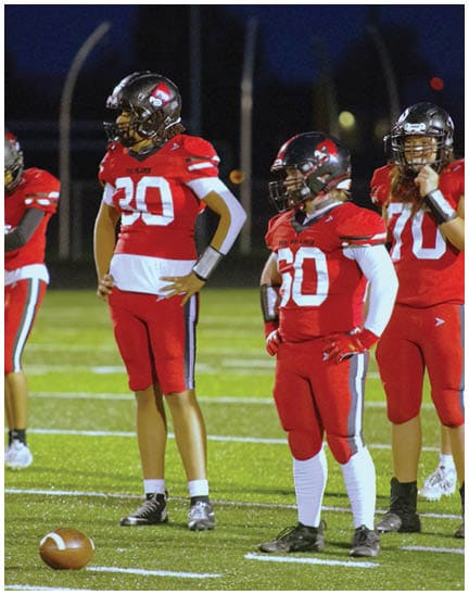 A football player wearing a blue jersey with the number 58 on it. Description generated by AI