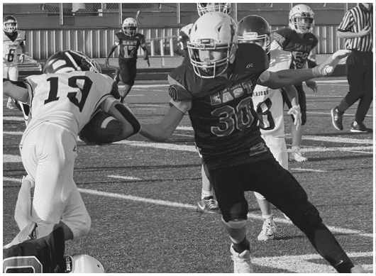 A football player catching a ball. Description generated by AI