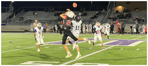 A football player catching a ball. Description generated by AI