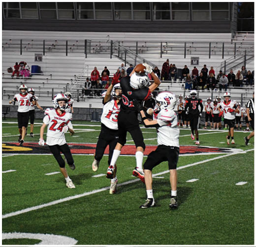 A football player catching a ball. Description generated by AI
