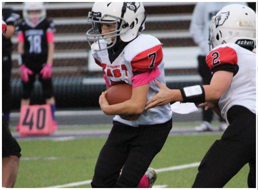 A football player catching a ball. Description generated by AI