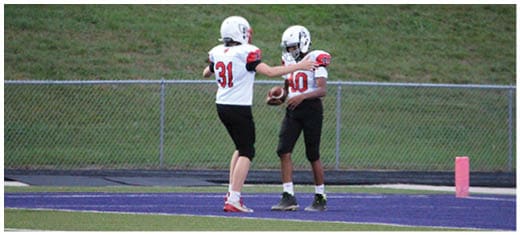 A football player catching a ball. Description generated by AI