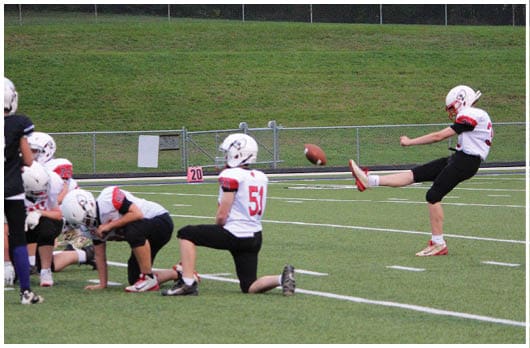 A football player catching a ball. Description generated by AI