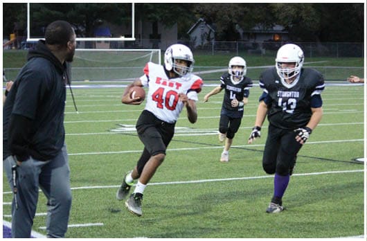 A football player catching a ball. Description generated by AI