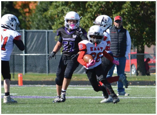 A football player catching a ball. Description generated by AI