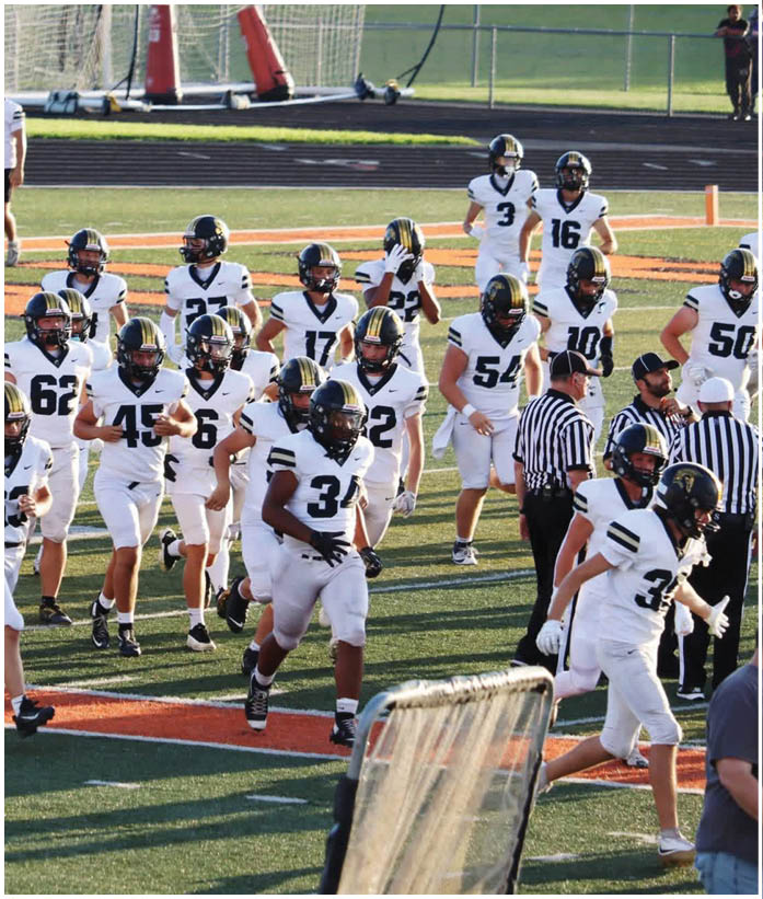 A group of football players wearing black and white uniforms. Description generated by AI