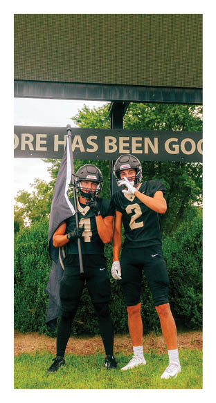 A football player is kneeling on the field, wearing a green jersey and a helmet. AI generated content