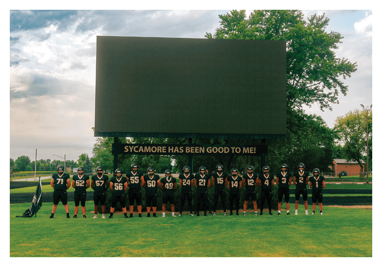 A group of football players on a field, one of them is running with a football. AI generated content