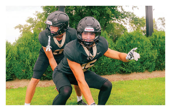 A group of football players wearing headphones and smiling. AI generated content