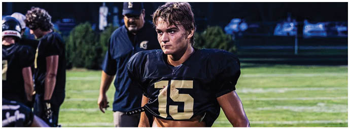 A football player wearing a blue and white uniform. Description generated by AI
