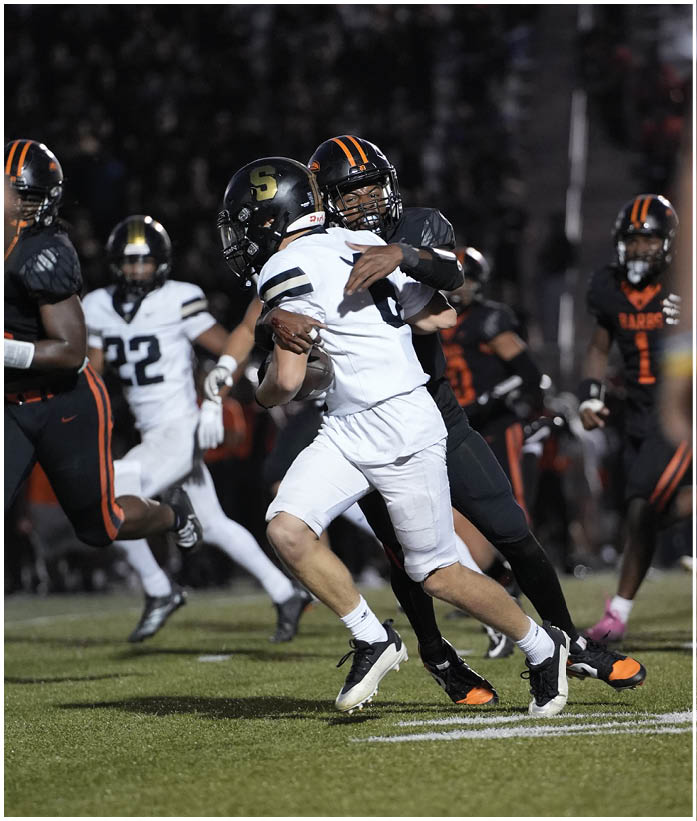 A group of football players wearing black and white uniforms. Description generated by AI